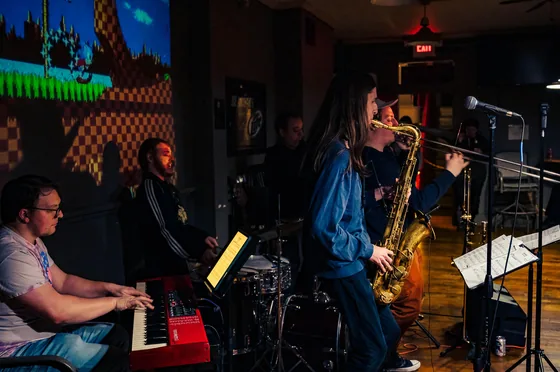 Fast Travel performing with a video game level projected on the wall behind the band